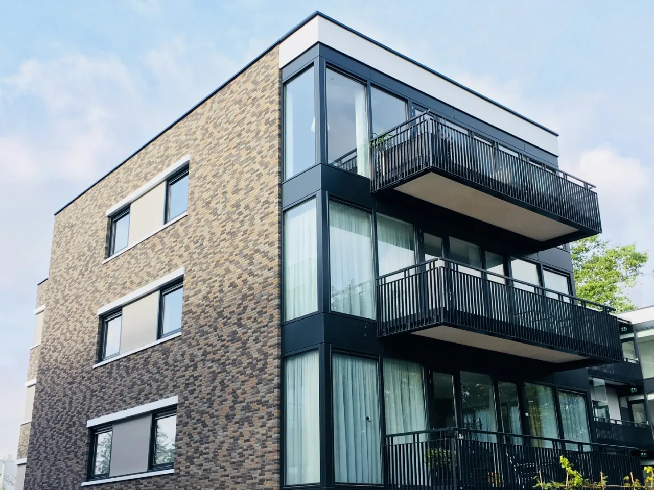 Modern appartementengebouw met baksteen en zwarte balkons