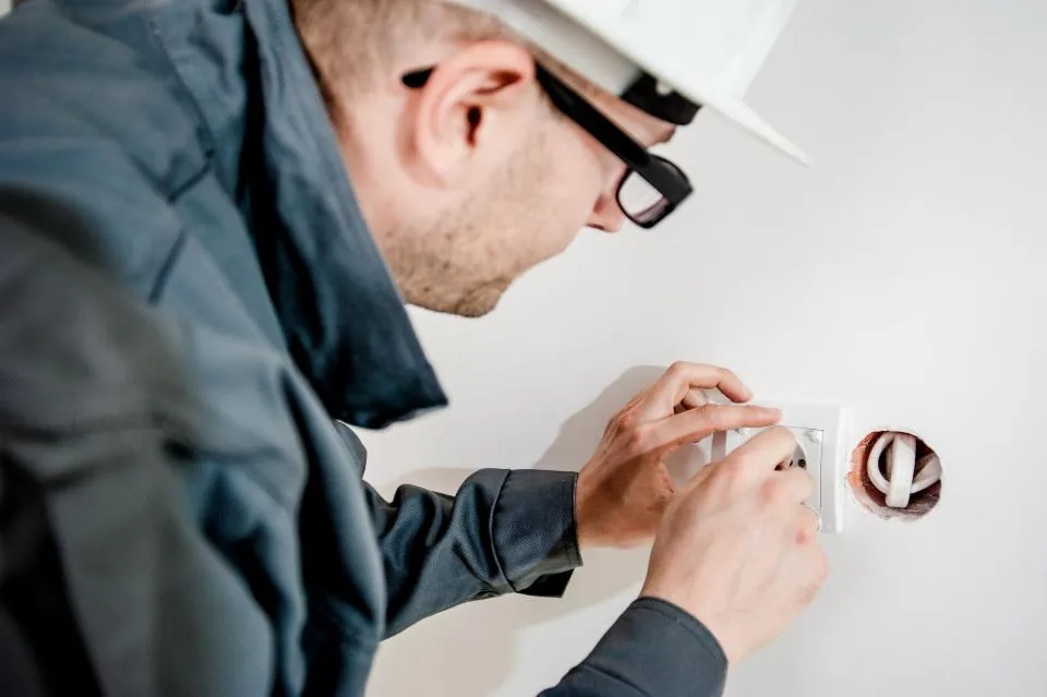 Vakman met helm monteert een stopcontact